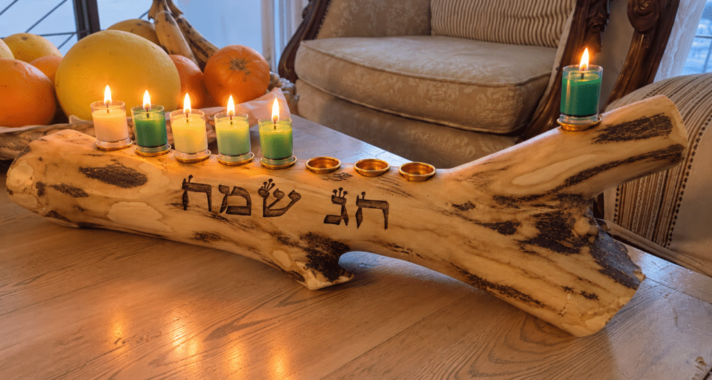 הדמיית חנוכיית חג שמח מעץ הדר עם נרות צבעוניים דולקים ושמש מוגבה